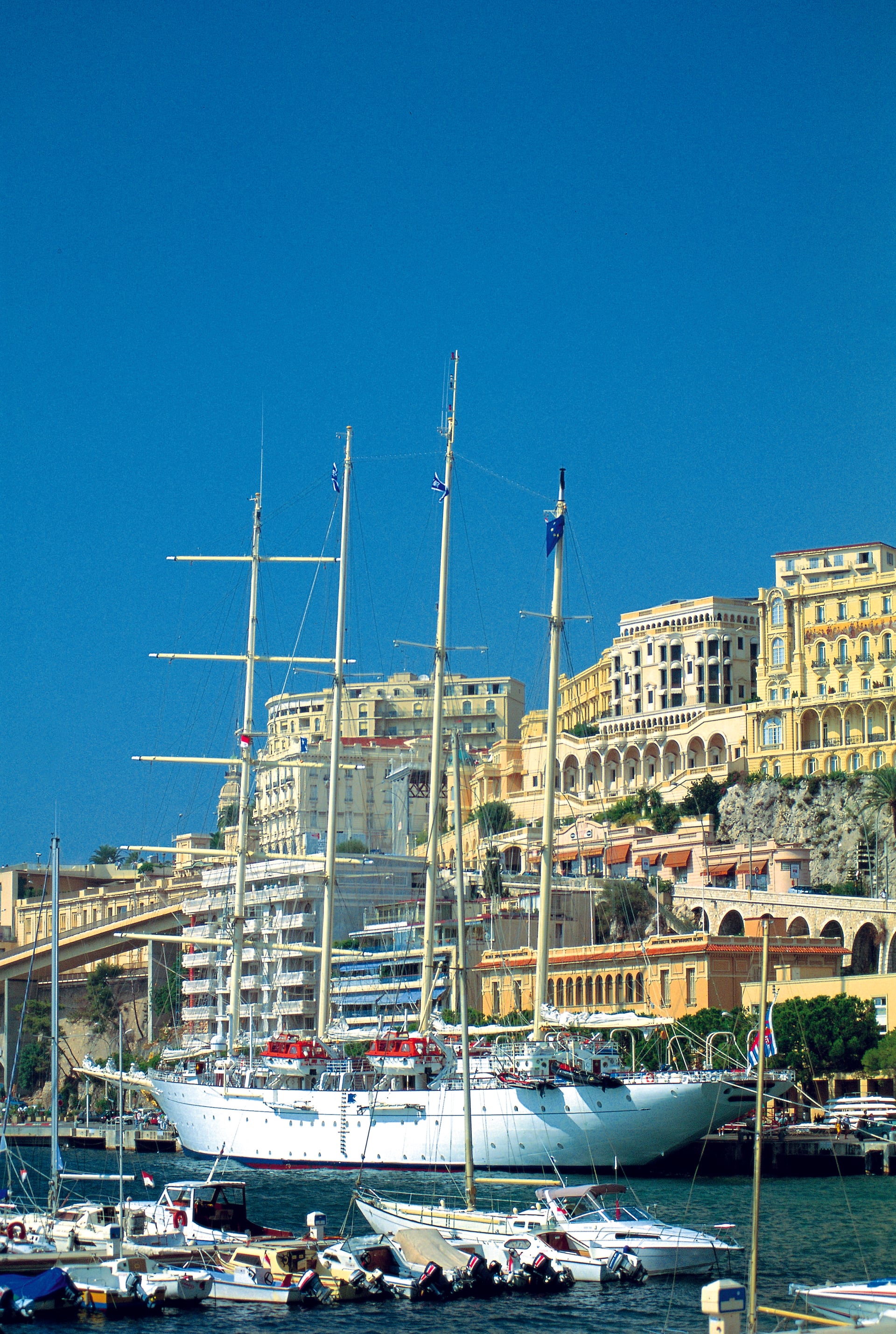 Hafen von Monaco mit Segelschiff, Yachten und den Belle-Époque-Fassaden am Felsen