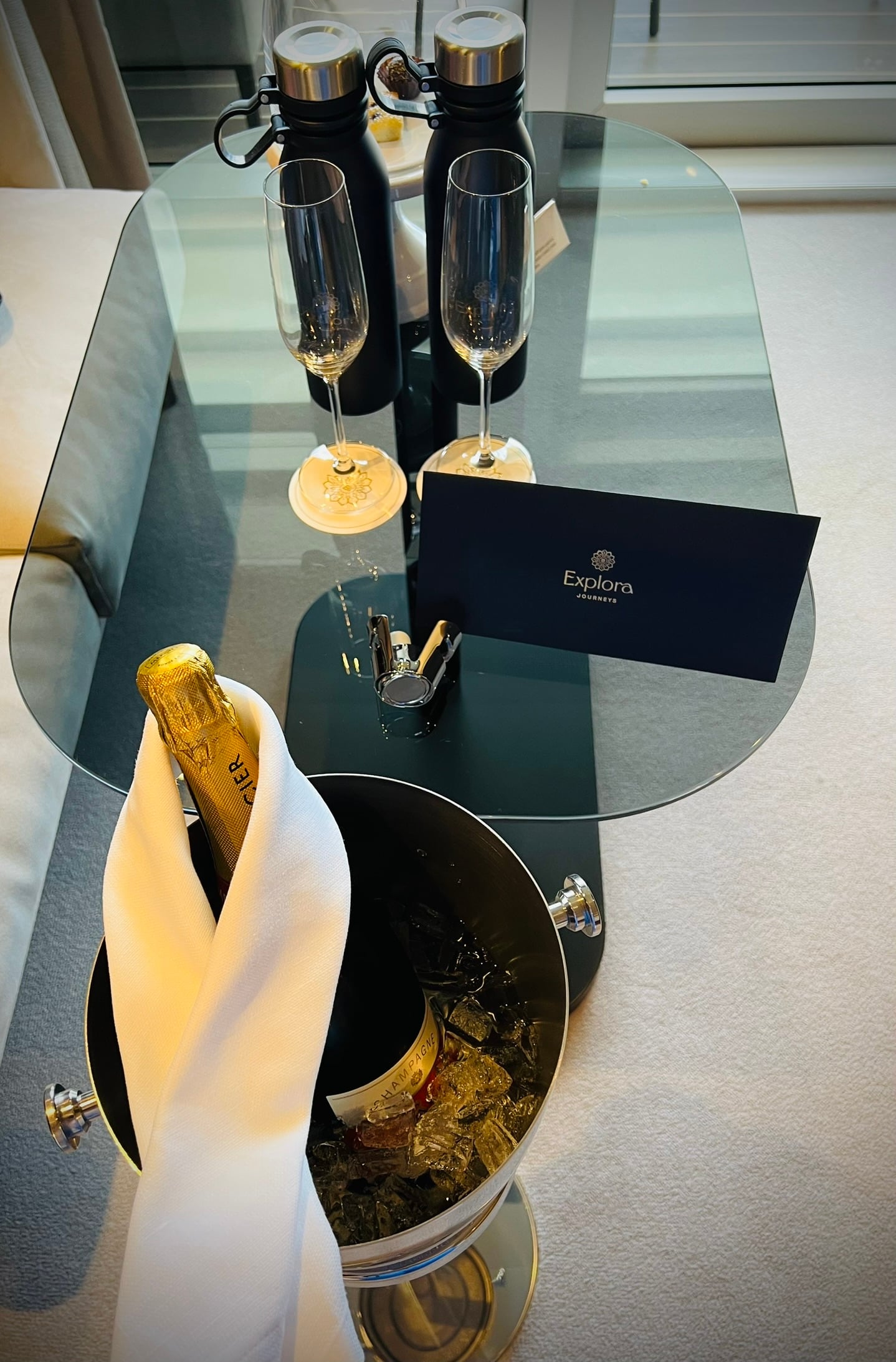 Begrüßung in der Suite: Champagner im Kühler, zwei Gläser und eine Karte von Explora Journeys